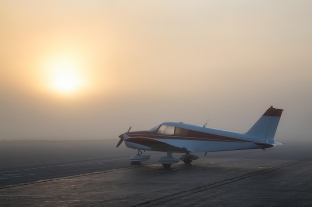 Lever de soleil brumeux à l'aéroport avec un avion