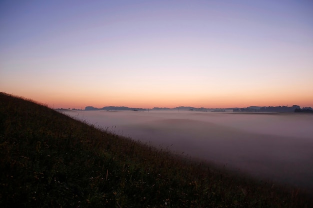 Lever de soleil coloré sur les collines dans le brouillard