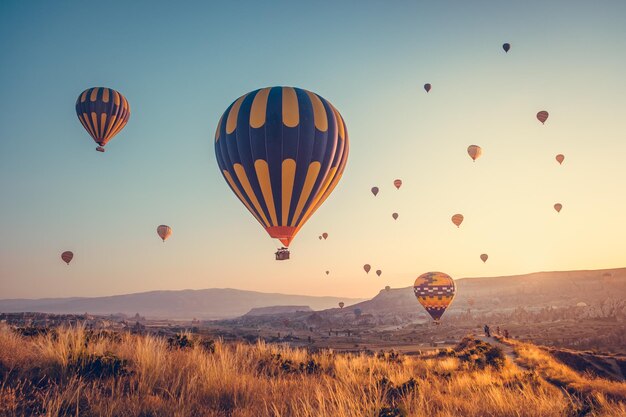 Photo lever de soleil incroyable avec des montgolfières colorées