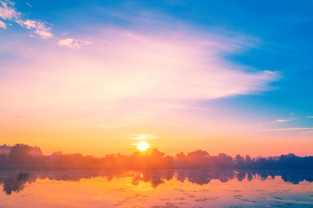 Lever de soleil magique sur le lac Paysage rural du matin brumeux