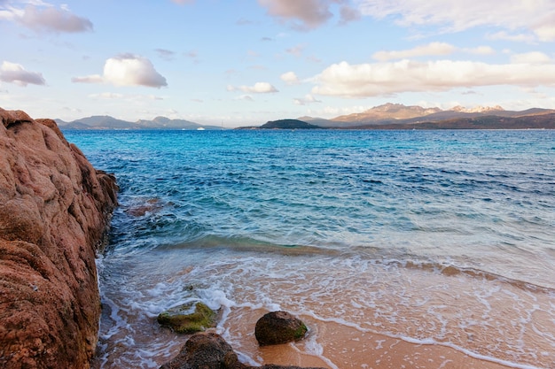 Lever de soleil romantique du matin sur la plage de Capriccioli à Costa Smeralda dans la mer Méditerranée sur l'île de Sardaigne en Italie. Ciel avec nuages