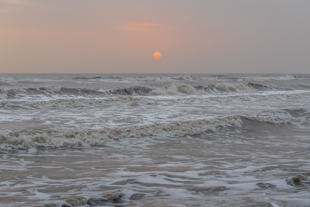 Lever de soleil sombre au paysage de mer orageuse