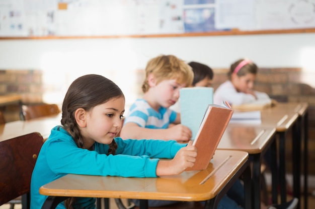 Élèves assis dans la salle de classe en lisant des livres