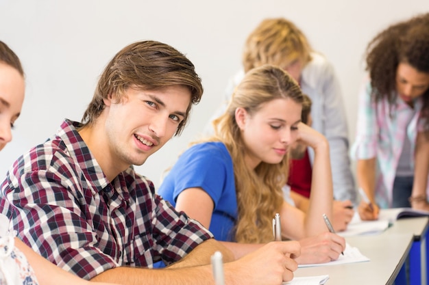 Élèves écrivant des notes en salle de classe