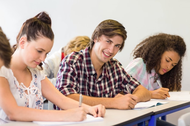 Élèves écrivant des notes en salle de classe