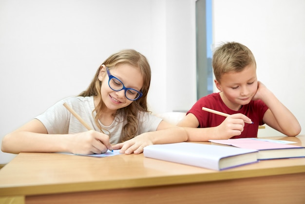 Élèves intelligents assis en classe et faisant des tests à l'école