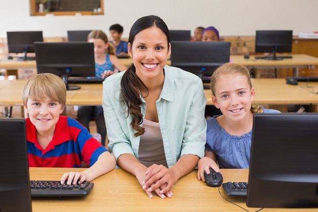 Élèves mignons en classe d&#39;informatique avec professeur