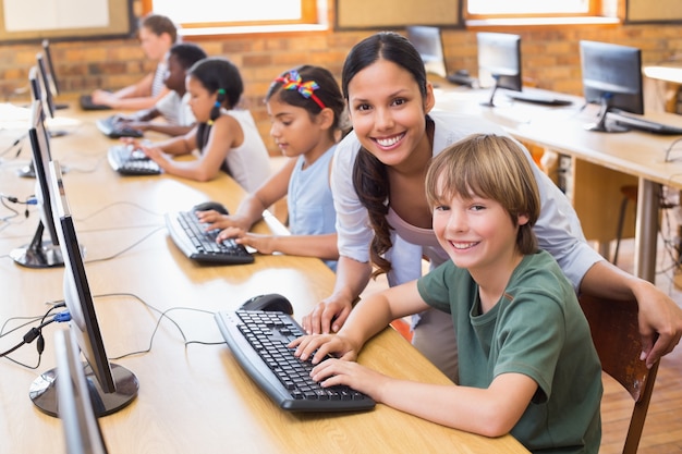 Élèves mignons en classe d&#39;informatique avec professeur