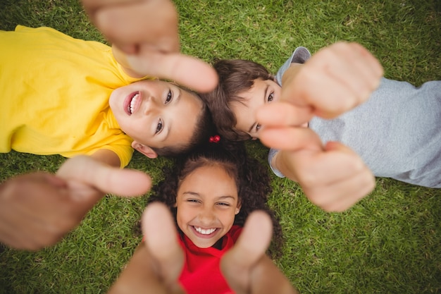 Élèves mignons couché sur l&#39;herbe en souriant