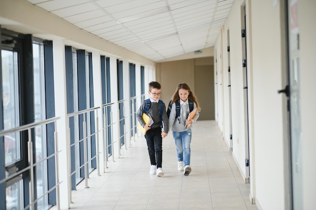 Élèves mignons courant dans le couloir de l'école primaire