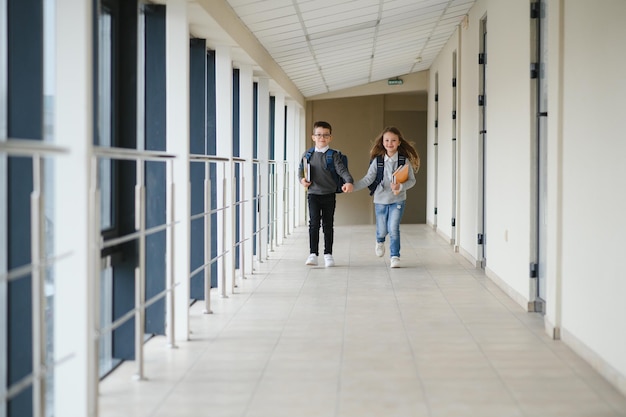 Élèves mignons courant dans le couloir de l'école primaire