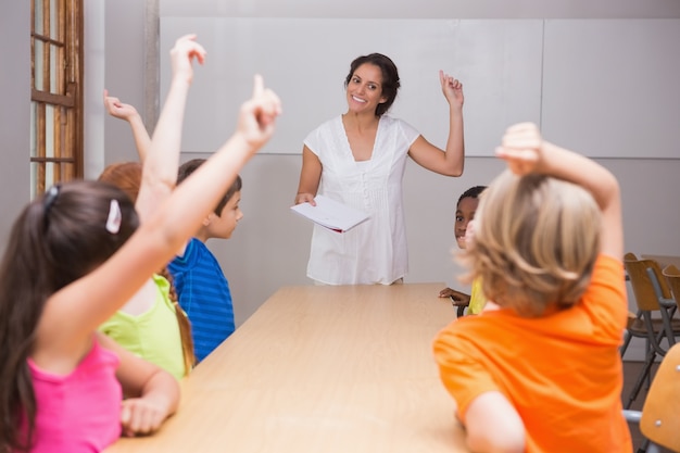 Élèves mignons levant les mains en classe