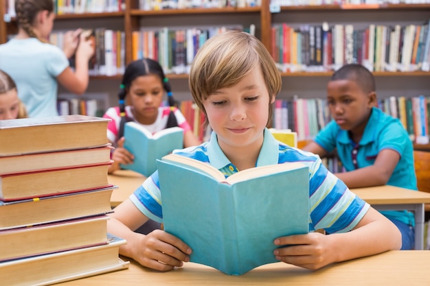 Élèves mignons lisant dans la bibliothèque