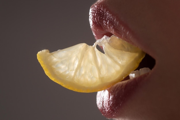 Lèvre rouge, bouche sertie de citron. Soin et beauté des lèvres. Lèvres sensuelles de beauté. Gros plan, macro avec la bouche de la belle femme.
