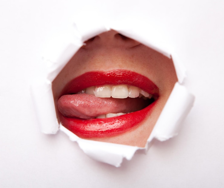 Photo lèvres de jeune beauté femme avec rouge à lèvres du trou de papier