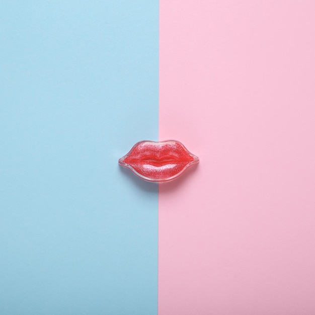 Les lèvres rouges sur un fond bleu rose Concept de beauté minimal