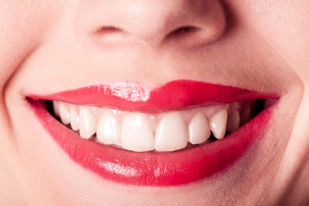 Lèvres rouges sourire gros plan avec des dents blanches