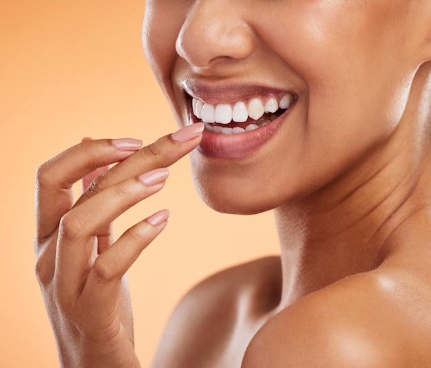 Lèvres et sourire de femme avec des dents pour le maquillage cosmétique et la main pour le traitement sur fond de studio Gros plan de la beauté féminine pour les soins de la bouche sourire heureux en satisfaction pour les soins de la peau orale