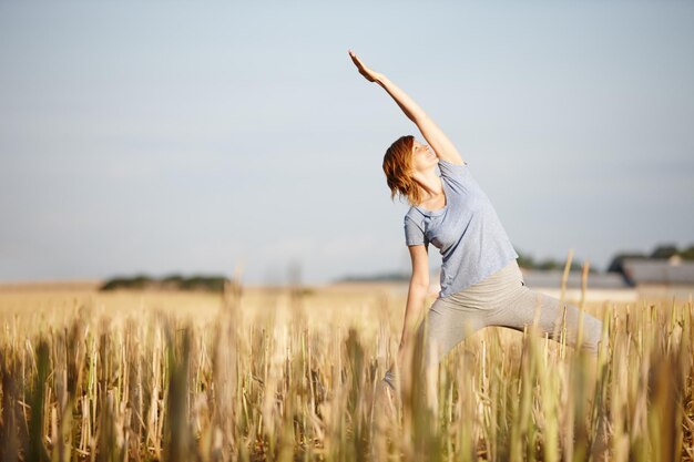 Liberté dans la nature Photo d'une jolie femme faisant du yoga dans un champ cultivé