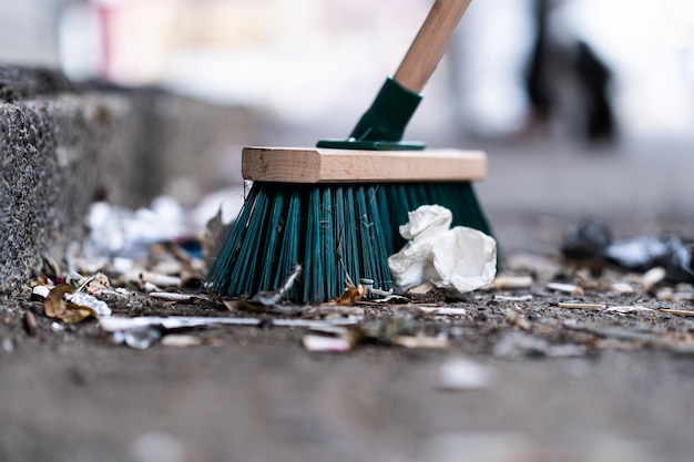 Libre d'un balai de rue verte utilisé dans le nettoyage d'une rue pavée