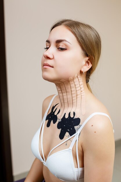 Libre d'une bande sur le cou d'une jeune femme Kinésithérapie avec bandes thérapeutiques