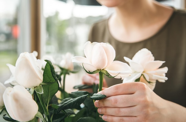 Libre un bouquet de roses dans les mains d'une femme fleuriste