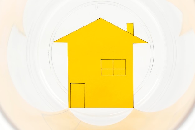Libre de carton en forme de maison jaune dans un bocal