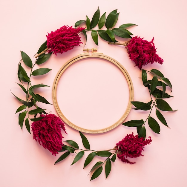 Libre un cercle de fleurs fraîches et un vert se trouvent sur un fond rose - espace copie