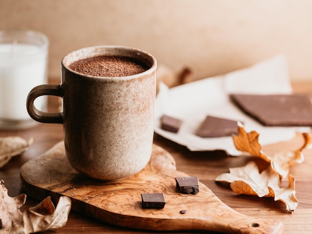 Libre de chocolat chaud dans une tasse en céramique sur la table d'automne ou d'hiver confortable encore la vie