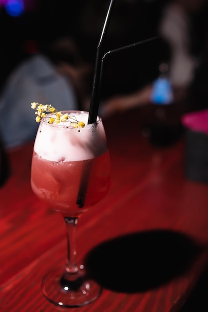 Libre d'un cocktail alcoolisé décoré d'une fleur dans un bar de discothèque