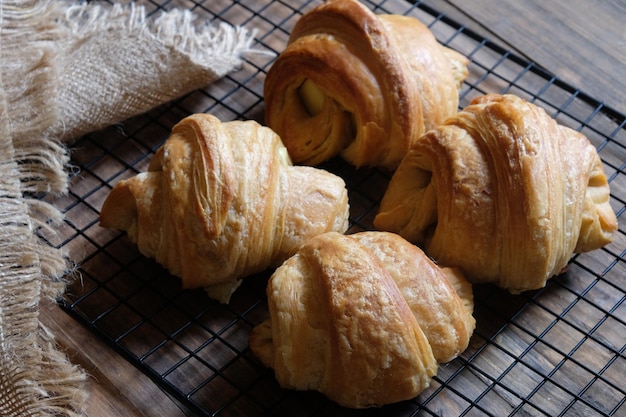 Libre de croissants sur une grille de refroidissement. pâte en forme de croissant. fourré au fromage, chocolat, jambon