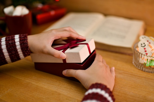 Libre de droit Une femme ouvrant une boîte-cadeau surprise à son bureau Cadeaux de vacances ou cadeau