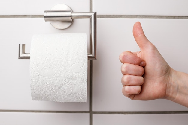 Libre d'une femme montrant un rouleau de papier toilette