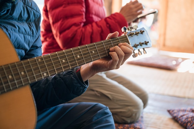 Libre homme jouant de la guitare acoustique entre amis