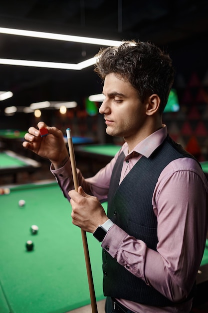 Libre homme joueur de billard frottant cue