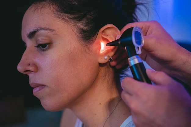 Libre d'une jeune femme latine ayant ses oreilles examinées avec un otoscope