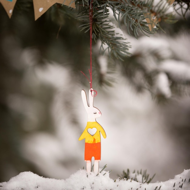 Photo libre d'un lapin multicolore suspendu à un arbre de noël fêtes et célébrations saisonnières