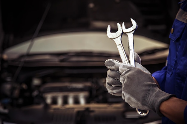 Libre main technicien tenant la clé pour réparer la voiture