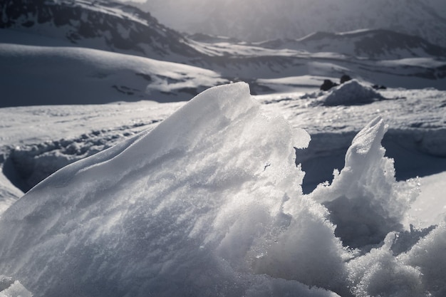 Libre d'un mur de neige translucide fondant sur fond de montagnes