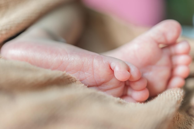 Libre pieds de bébé allongé sur le lit à la lumière du jour