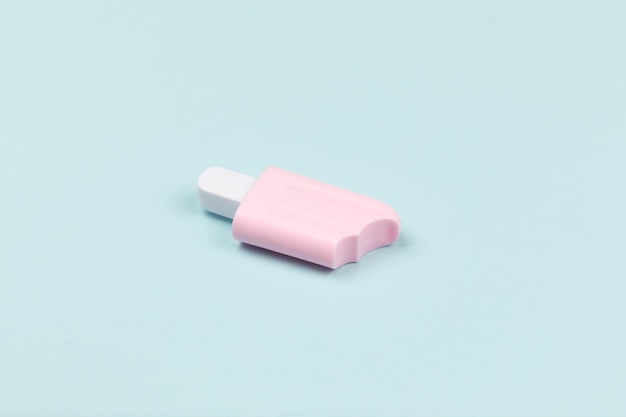 Libre d'un popsicle rose sur la glace de surface cyan