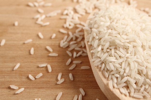 Libre de riz dans une cuillère en bois sur une surface en bois