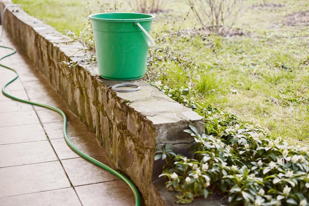 Libre d'un seau près d'un tuyau d'arrosage dans un jardin