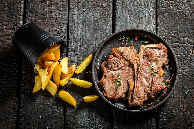 Photo libre de tbone steak frais et frites aux herbes