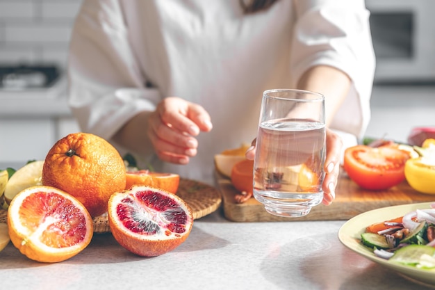 Libre un verre d'eau dans les mains des femmes dans la cuisine