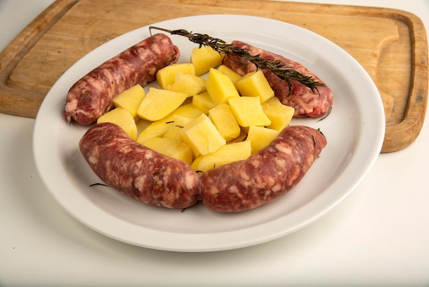 Photo lier des saucisses avec un pain fraîchement cuit sur une planche à couper en bois isolée sur blanc avec un espace de copie