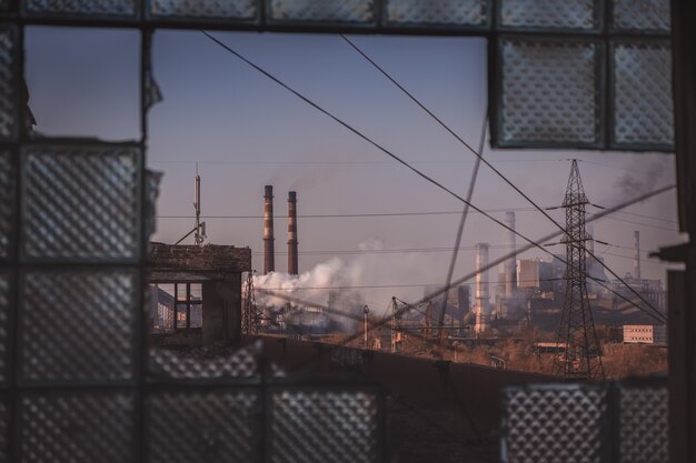 Lieu abandonné avec vue sur la zone industrielle de fond industriel sur la fumée des tuyaux