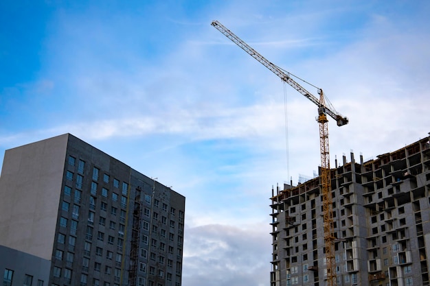 Lieu intérieur pour de nombreux immeubles de grande hauteur en construction et grues sous un ciel bleu.