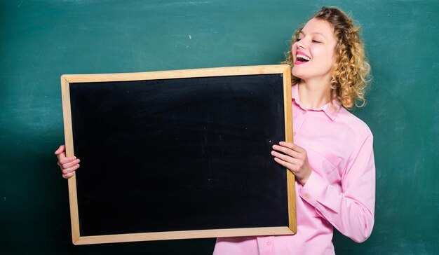 Lieu de rétroaction des clients pour écrire une tâche heureuse étudiante fille tenir un tableau blanc enseignante au tableau noir copie espace voici votre concept d'annonce de panneau d'informations publicitaires