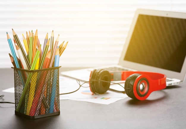 Lieu de travail de bureau avec écouteurs et crayons pour ordinateur portable